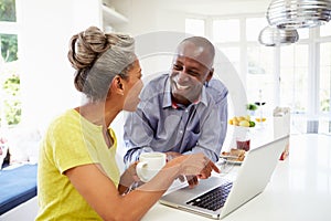 Mature African American Couple Using Laptop At Bre