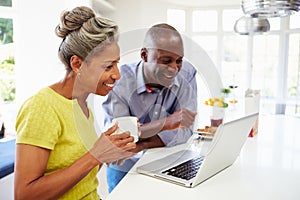 Mature African American Couple Using Laptop At Bre