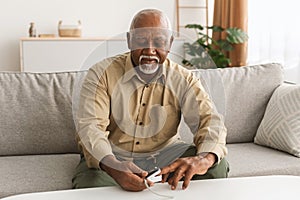 Mature African Male Using Pulse Oximeter Measuring Saturation Level Indoor