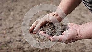 Mature agronomist's hands controlling and checking quality and fertiliz of the soil before planting in an ecological