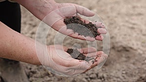 Mature agronomist's hands controlling and checking quality and fertiliz of the soil before planting in an ecological