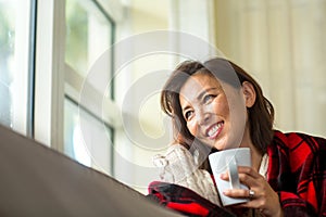 Mature Asian woman enjoying a cup of coffee.