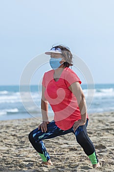 Mature asian woman stretching at the beach