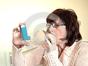 Mature attractive lady using asthmatic pump spacer device to ease condition