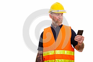 Mature bearded man construction worker using mobile phone