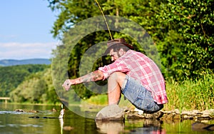 Mature bearded man with fish on rod. big game fishing. relax on nature. fly fish hobby. Summer activity. successful