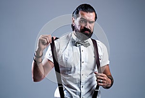 mature bearded man hipster with moustache wear suspenders and bow tie, vintage fashion look