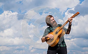 mature bearded man looking casual trendy playing guitar, acoustic music