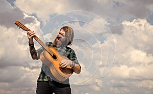 mature bearded man looking casual trendy playing guitar, acoustic music