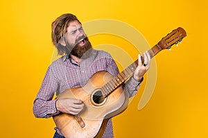 mature bearded man looking casual trendy playing guitar, music