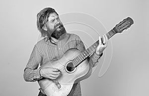 mature bearded man looking casual trendy playing guitar, music