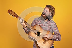 mature bearded man looking casual trendy playing guitar, music