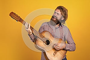 mature bearded man looking casual trendy playing guitar, music