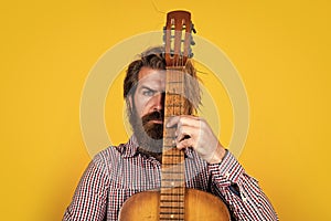 mature bearded man looking casual trendy playing guitar, singer