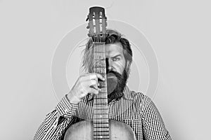 mature bearded man looking casual trendy playing guitar, singer