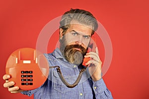 mature bearded man talk on retro phone. vintage technology in modern life. young man talking on telephone. senior man