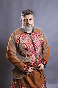 Mature bearded man in traditional historic clothes