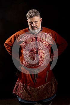 Mature bearded man in traditional medieval historic clothes studio portrait.
