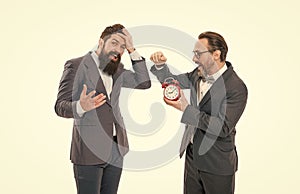 mature bearded men in formal suit hold alarm clock. deadline. late again. angry and exhausted businessmen. bad morning