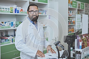 Mature bearded phrmacist working at is drugstore