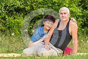 Mature beautiful couple in love on a green lawn