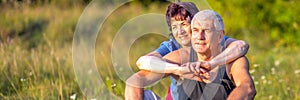 Mature beautiful couple in love on a green lawn in a park