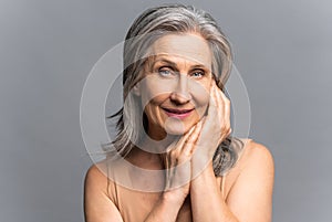 Mature beautiful European woman isolated on grey background