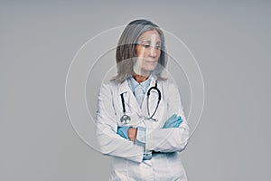 Mature beautiful female doctor in face shield keeping arms crossed