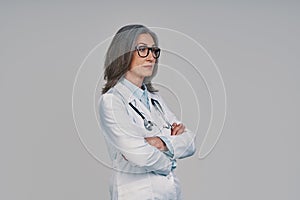 Mature beautiful female doctor looking away and keeping arms crossed