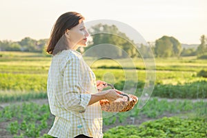 Mature beautiful woman farmer with basket of fresh eggs