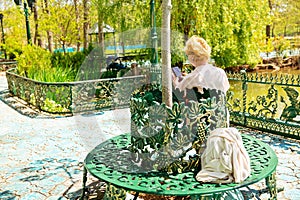 Mature beautiful woman traveler, sits on the bench of the park