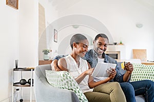 Mature black couple doing online shopping with credit card card at home