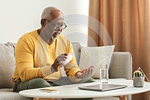 Mature Black Man Taking Medication Pill At Home