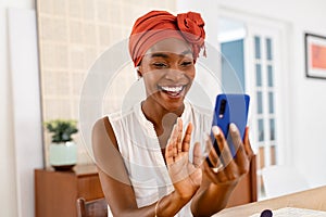 Mature black woman doing video call on smartphone at home