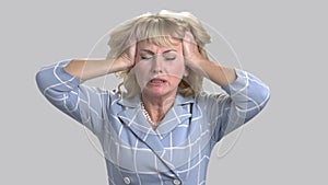 Mature blond woman feeling headache.