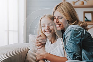 Mature blonde woman hugging daughter. Concept of reconciliation of mother with daughter.