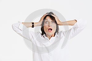 Mature brunette woman expressing surprise while holding her head