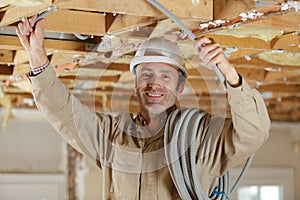 mature builder installing cable trunking in property