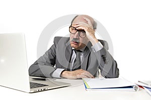 Mature business man with bald head on his 60s working stressed and frustrated at office computer laptop desk looking tired