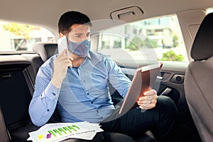 Mature business man with face mask working during travelling to office
