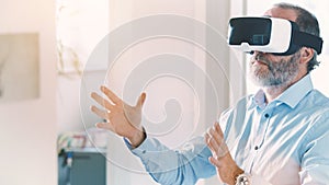 Mature business man wearing virtual reality googles / VR Glasses