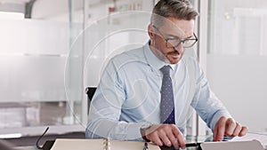 Mature business man working on digital tablet in office