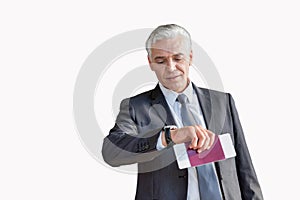 Mature businessman checking time on his watch after checked in at airport