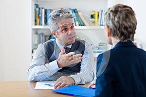 Mature businessman criticising lazy employee