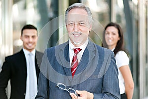 Mature businessman in front of a group of business people outdoor