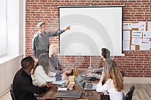 Mature Businessman Giving Presentation In Meeting