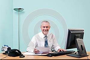 Mature businessman sat at his office desk