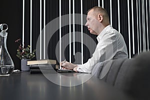 Mature businessman sitting at conference table. Confident man taking part in corporate or strategy discussion or in