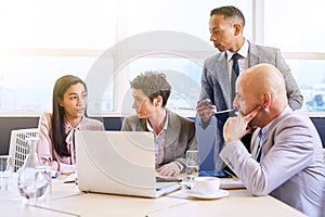 Mature businessman supervising his employees as they work