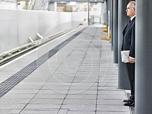 Mature businessman waiting at train station